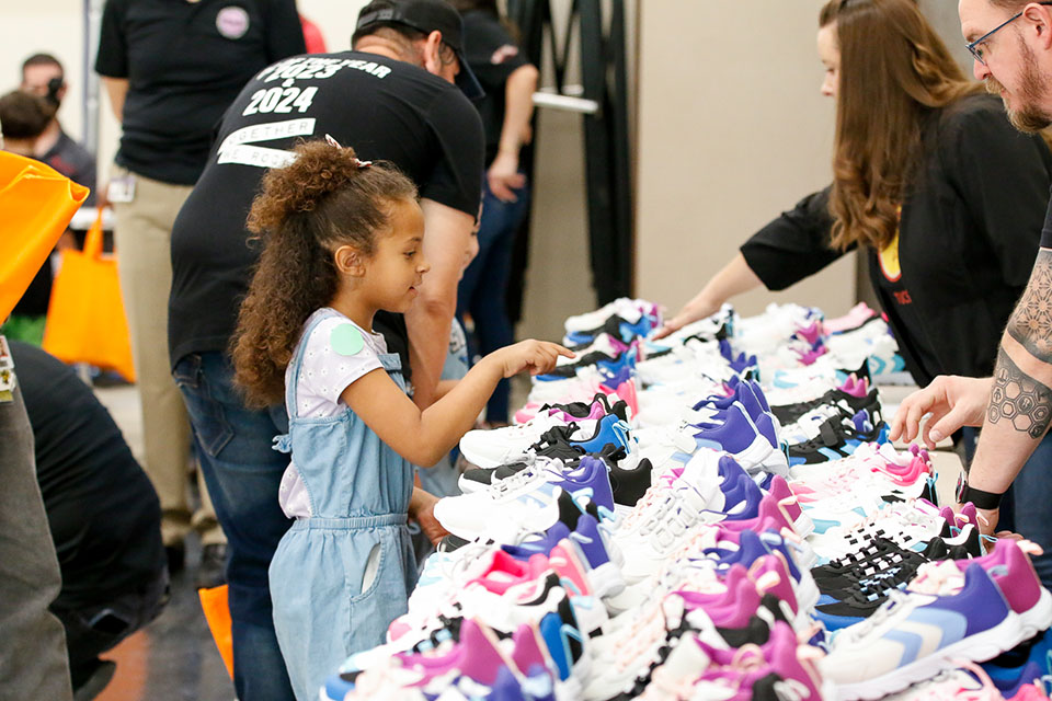 A little girl points to the pair of shoes she wants